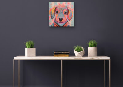 Buntes Pop-Art-Gemälde eines kleinen Hundes in einem modernen Esszimmer über einem großen, dunklen Tisch.