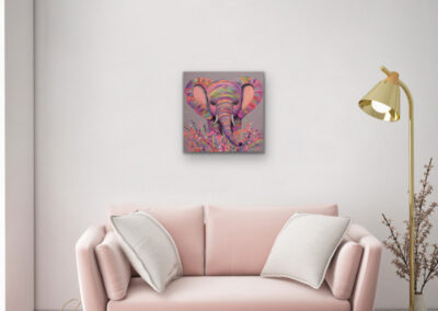 Modernes Pop-Art Gemälde eines farbenfrohen Elefanten über einer hellrosa Couch mit Kissen und einer eleganten, goldenen Stehlampe.