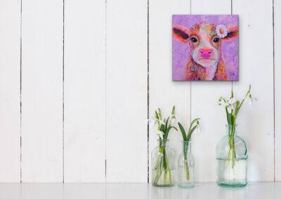 Quadratisches, farbenfrohes Neo-Pop-Art Gemälde eines süßen Kalbs mit einer Blume im Haar an einer weißen Holzplanken-Wand über Frühlingsblumen in Glasvasen.