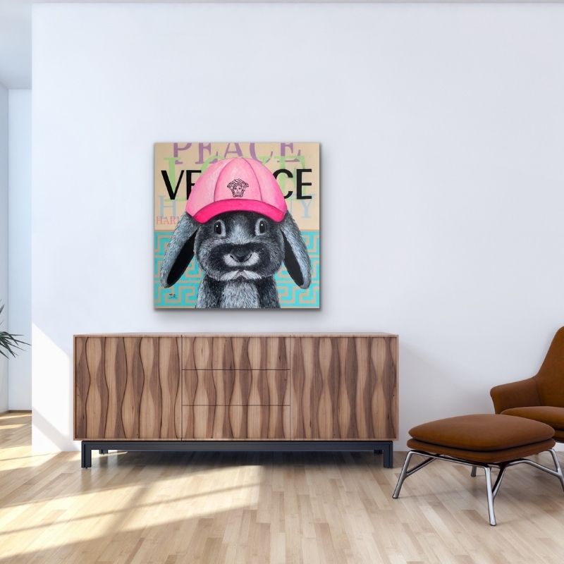 Freches Neo-Pop-Art Gemälde eines Hasen mit einer pinken Kappe und dem Schriftzug "PEACE" von Silke Timpe über einer modernen Holz-Konsole und neben einem Ledersessel. Das farbenfrohe Kunstwerk schafft eine fröhliche, inspirierende Atmosphäre im Jugendzimmer oder trendigen Wohnbereich. Neo-Pop-Art Hase Silke Timpe.