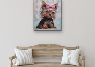 Quadratisches, buntes Hunde-Wandbild im Pop-Art-Stil aufgehängt an einer hellen Wand über einer rustikalen Holzbank mit weißen Kissen.