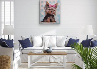 Farbstarkes Pop-Art-Hundeportrait eines kleinen Yorkshire Terriers über einem weißen Sofa mit blauen Kissen vor einer weißen Holzplanken-Wand.