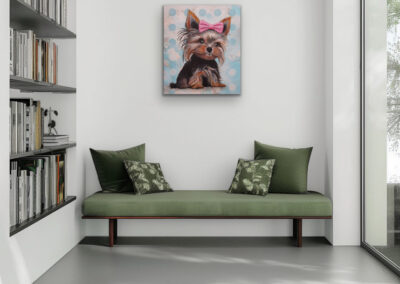 Farbenfrohes Pop-Art Hunde-Kunstwerk als Wanddekoration in einer gemütlichen Leseecke über einer grünen Sitzbank mit Kissen.