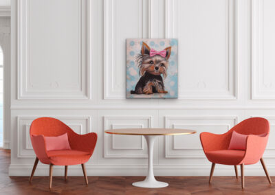 arbstarkes Yorkshire Terrier Gemälde im Pop-Art-Stil an einer weißen Wand mit edlen Wandpaneelen über einem runden Tisch und zwei roten Sesseln.