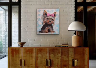 arbenfrohes Hundeportrait im Pop-Art-Stil an einer hellen Ziegelwand über einer rustikalen Vintage-Holzkommode.