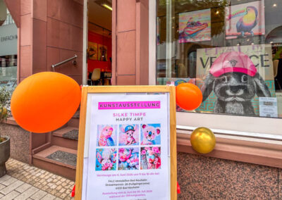 chaufenstergestaltung mit moderner Kunst: Farbenfrohe Tierporträts von Silke Timpe im Neo-Pop-Art-Stil mit urbanen Einflüssen ziehen die Blicke im Außenbereich auf sich.